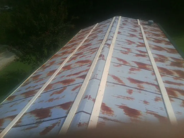 Rusted metal roof panels with new wood purlins before replacement — Storm Damage Roof Repair in Proctorsville by Roofing Brothers