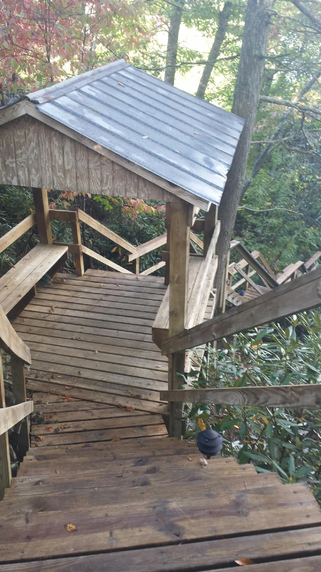 Metal roofed shelter over wooden steps on a wooded walkway — Skylight Repair & Installation work by our crew in Proctorsville