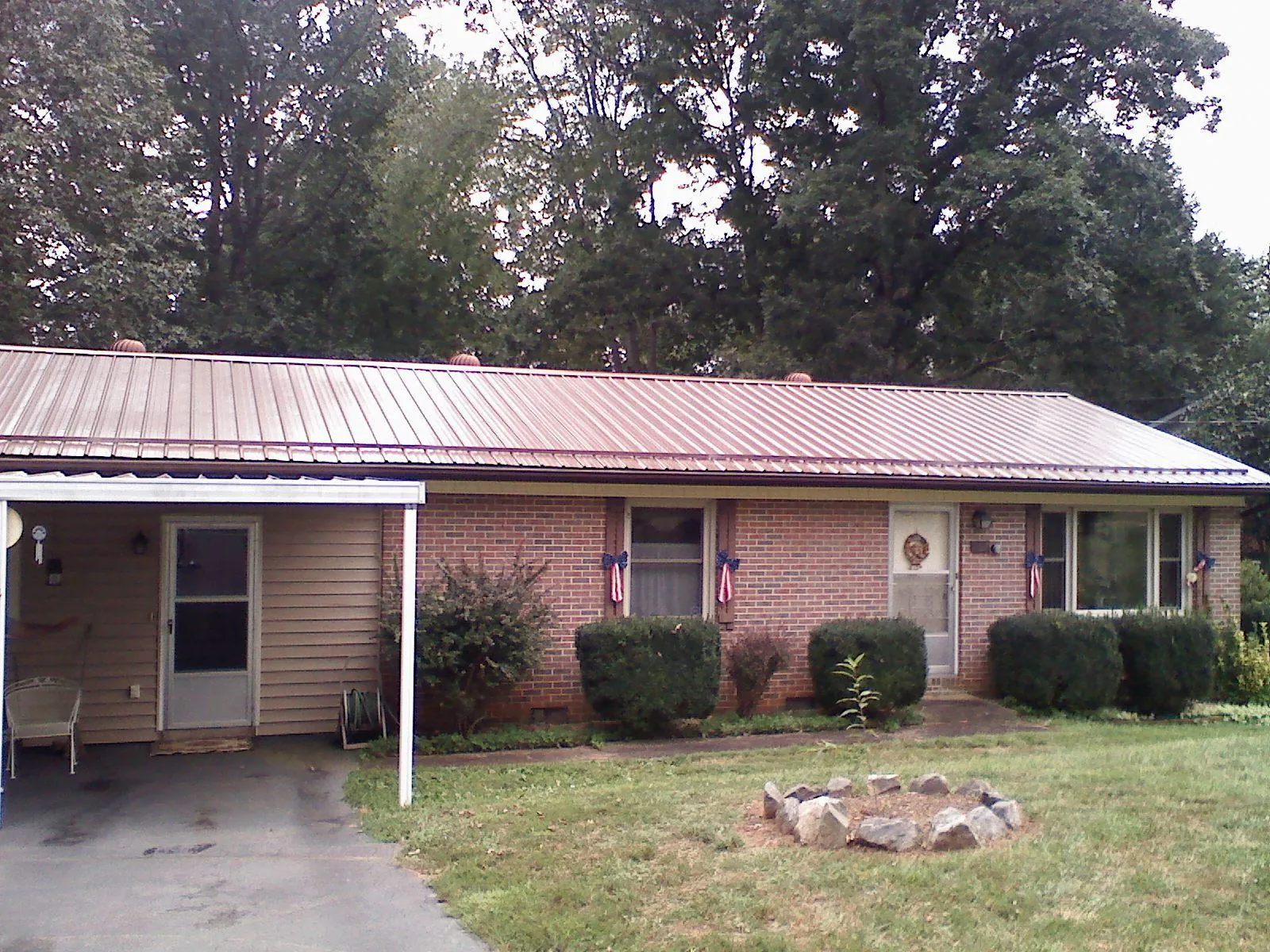 Bronze metal roof and carport on a brick ranch home — Roof Repair work by our crew in Proctorsville